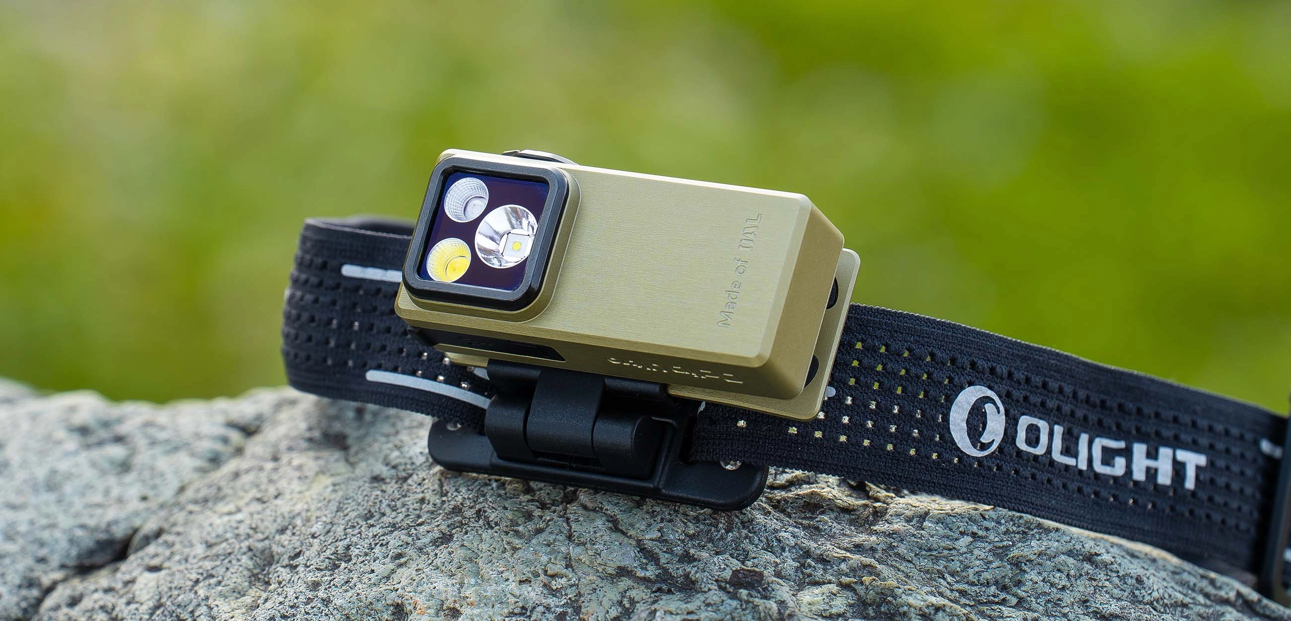 Olight Oclip Ultra ist drau&szlig;en an einem Kopfband befestigt und liegt auf einem Felsen